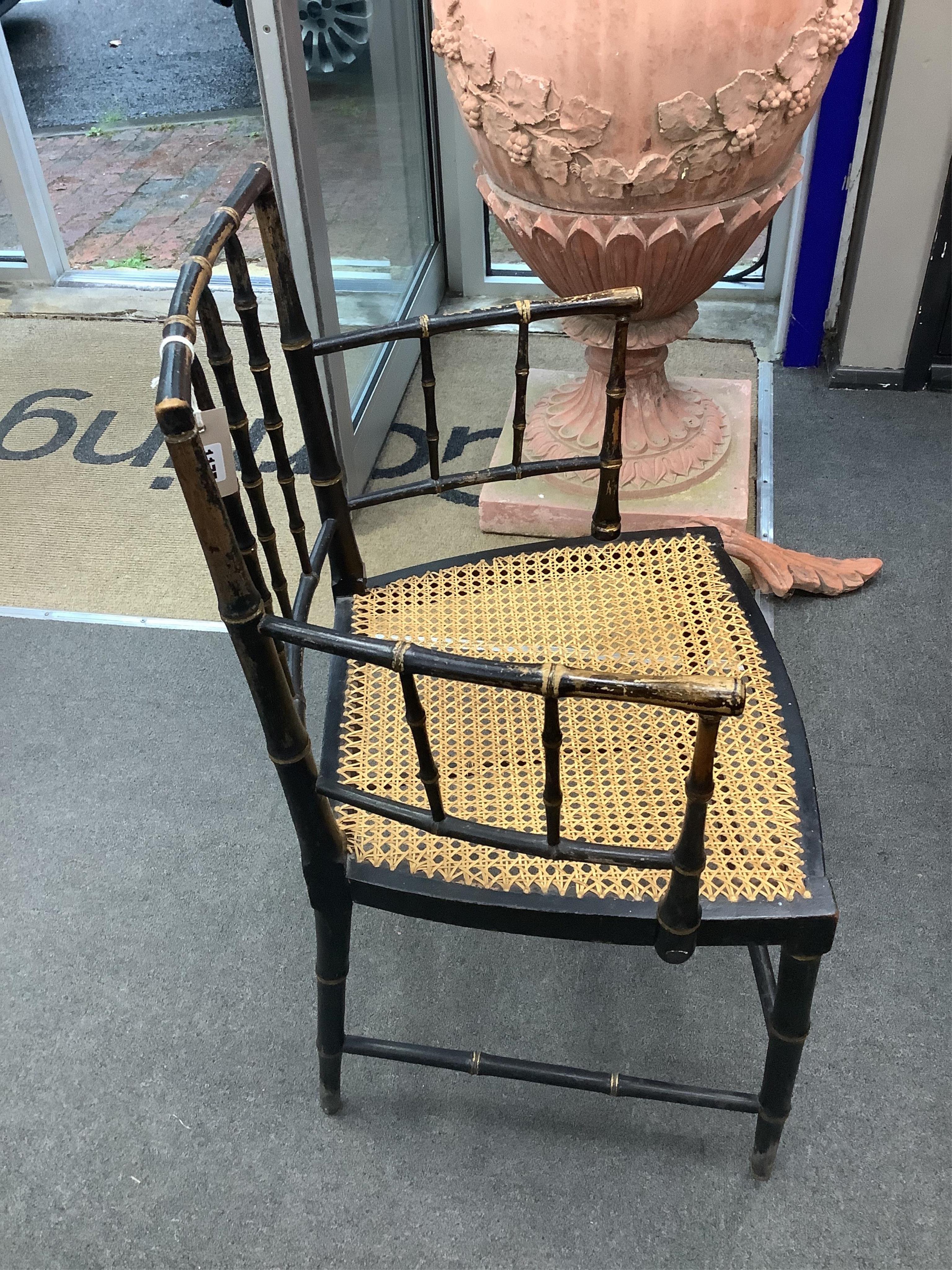 A set of four Regency ebonised simulated bamboo cane seat elbow chairs, width 56cm, depth 43cm, height 86cm. Condition - fair (one stretcher detached but present)